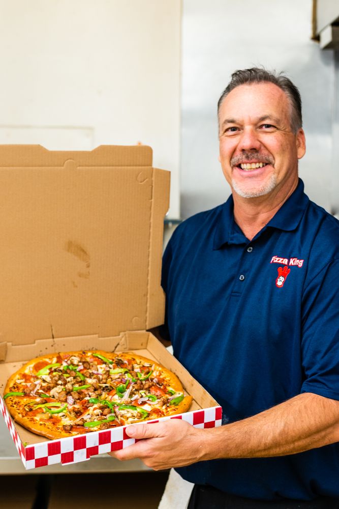 Owner holding pizza